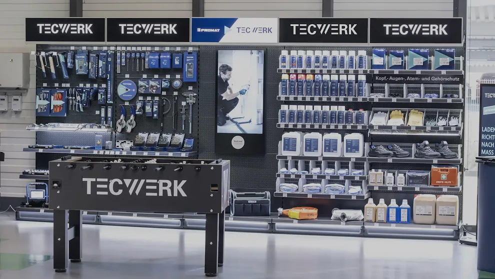 TECWERK-Verkaufsdisplay mit Werkzeugen, Arbeitskleidung und Tischkicker.